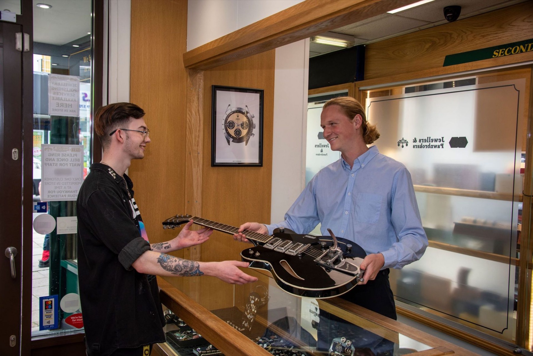 A guitar being handed over the counter